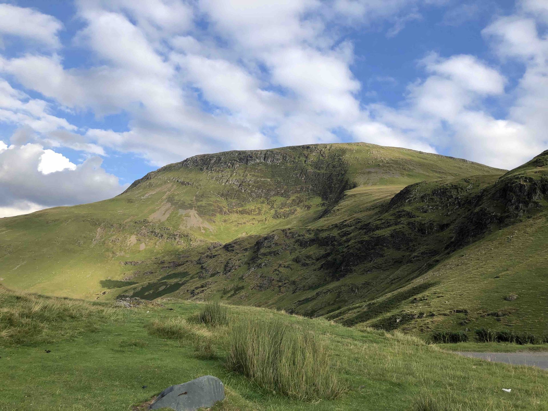 Peaceful green hillside under a blue sky, symbolising calm and clarity, featured on the contact page of June Reid Counselling.
