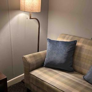 Interior of June Reid Counselling room with comfortable sofa, cushions, and soft lighting.