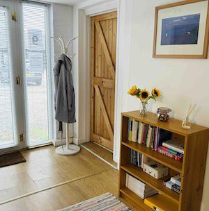 Waiting area at June Reid Counselling with bookshelf, coat stand, and welcoming decor.